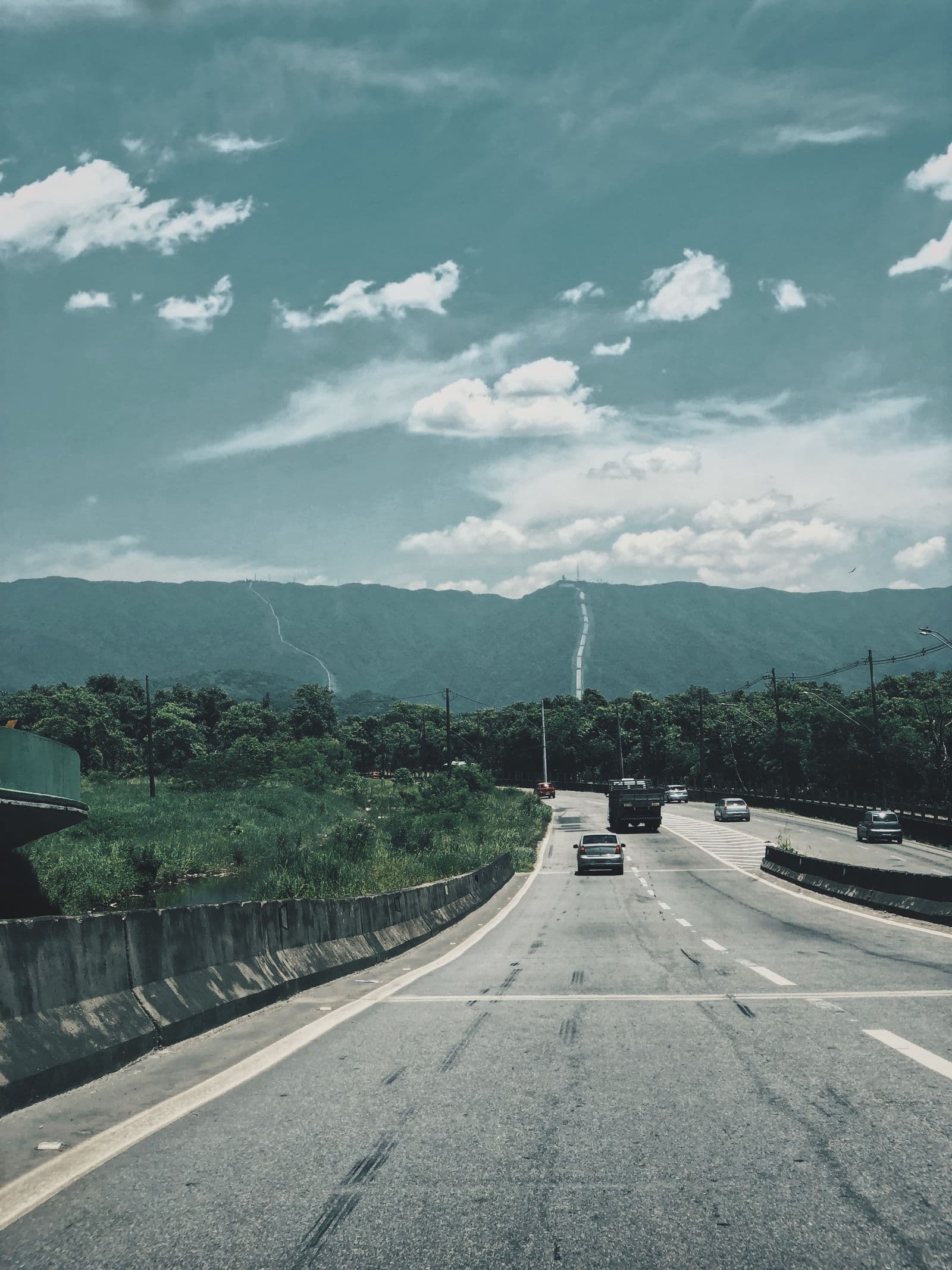 Open highway winding through a scenic landscape towards a border